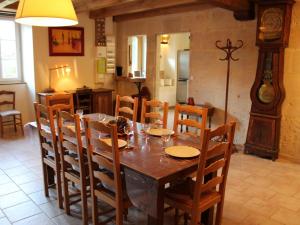 a dining room with a wooden table and chairs at Gîte charentais avec cour privative, baby-équipement, télétravail, vélos, BBQ, animaux acceptés - FR-1-653-170 in Chalais