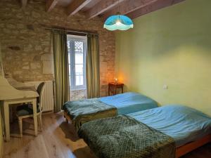 a bedroom with two beds and a desk and a window at Gîte avec Piscine Chauffée, Jacuzzi et Jardin Privé - FR-1-653-156 in Charras +27 photos