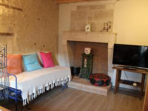 a living room with a couch and a fireplace at Gîte charentais avec cour privative, baby-équipement, télétravail, vélos, BBQ, animaux acceptés - FR-1-653-170 in Chalais