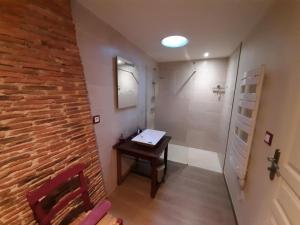 a bathroom with a sink and a brick wall at Gîte charentais avec cour privative, baby-équipement, télétravail, vélos, BBQ, animaux acceptés - FR-1-653-170 in Chalais +27 photos