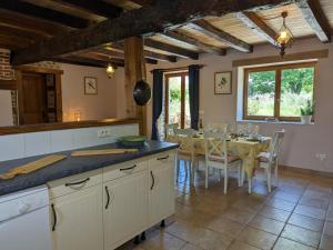 une cuisine avec une table et une salle à manger dans l'établissement Gîte Massignac, 4 pièces, 6 personnes - FR-1-653-213, à Massignac