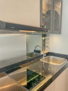 a kitchen counter with a sink and a microwave at B Landmark Residence in Bandung