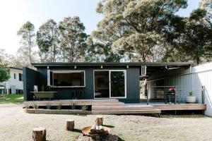 een huis met een groene buitenkant en een terras bij Farm & Sea Studio in Pyree