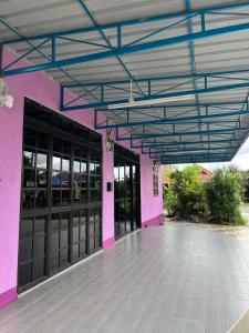 a pink building with black doors and a blue ceiling at Roomstay Budget Kuala Terengganu Desa Chendering Private Bathroom in Kuala Terengganu