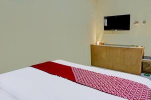 a bedroom with a bed with a red blanket on it at OYO 91825 Ayu Lestari Homestay in Nganjuk