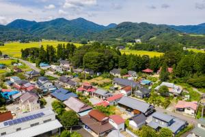una vista aérea de una pequeña ciudad frente a las montañas en まるごの宿-耕-, en Sukagawa
