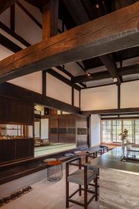 a large room with tables and chairs and a large window at まるごの宿-耕- in Sukagawa