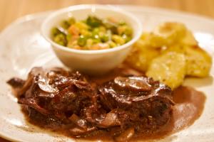talerz z mięsem i miskę z jedzeniem w obiekcie VillaBeatriz Lodge&Spa w mieście Vilcabamba