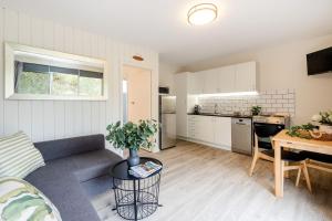 a living room and kitchen with a couch and a table at Surfrider 3 in Mollymook
