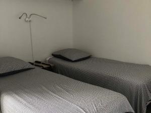 dwa łóżka ustawione obok siebie w pokoju w obiekcie Appartement avec Balcon Proche des Thermes, Étang et Commerces - Climatisé, Animaux Admis - FR-1-503-134 w mieście Balaruc-les-Bains