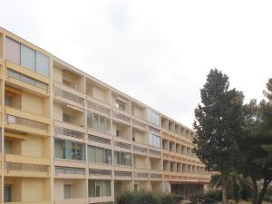 apartamentowiec z drzewem przed nim w obiekcie Appartement avec Balcon Proche des Thermes, Étang et Commerces - Climatisé, Animaux Admis - FR-1-503-134 w mieście Balaruc-les-Bains