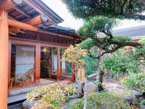 KOUBOUNOYU IKONASOU في شيزوكا: منزل به نافذة وكرسي في حديقة