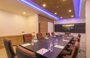Anda Sea Tales Resort-SHA Plus في شاطيء آونانغ: قاعة المؤتمرات مع طاولة وكراسي طويلة