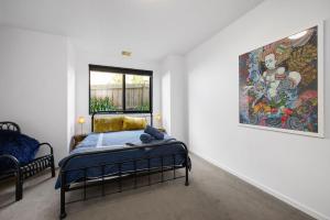 een slaapkamer met een bed en een schilderij aan de muur bij Sea View Beach House 11a in Torquay