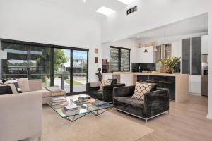 a living room with a couch and a table at Araluen House Werri Beach Gerringong in Gerringong