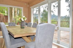 Villa Panorama في Kalorama: غرفة طعام مع طاولة وكراسي خشبية