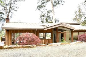 Casa de madera con porche y árbol en Villa Panorama en Kalorama