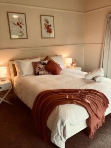 una camera da letto con un grande letto bianco con cuscini di Hillview Cottage 