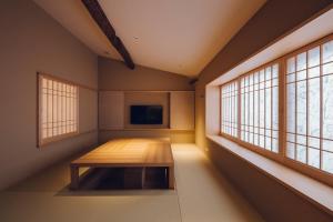 a room with a wooden bench in a room with windows at Yuhi House Kyoto Dog Friendly in Kyoto