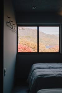 a bedroom with a window with a view of a mountain at hotel norm. fuji in Fujikawaguchiko