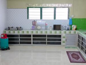 a green and white kitchen with a counter top at Hidden Homestay in Marang