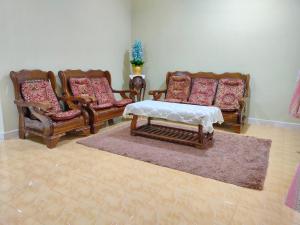 a living room with three chairs and a table at Hidden Homestay in Marang
