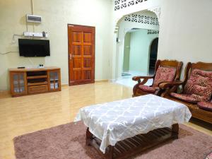 a living room with two chairs and a television at Hidden Homestay in Marang