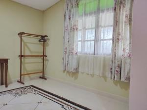 a room with a window with curtains and a tile floor at Hidden Homestay in Marang