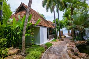 een huis met een zwembad en palmbomen bij Samui Natien Resort in Chaweng Beach