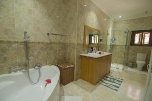 a bathroom with a bath tub and a sink at Pension Michel Villa Roche Bois in La Digue