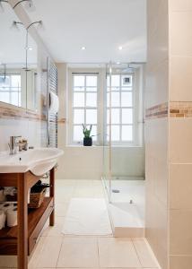 a bathroom with a sink and a shower at ARCORE Premium Apartments Broad Court in London