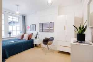 a bedroom with a bed and a desk and a chair at ARCORE Premium Apartments Broad Court in London