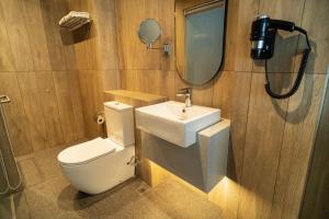 a bathroom with a toilet and a sink and a mirror at Hotel Bencoolen at Hong Kong Street in Singapore