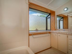 a bathroom with a tub and a sink and a window at Relax On Courtney - Pauanui Holiday Home in Pauanui +27 photos