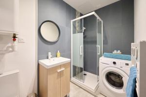 a bathroom with a washing machine and a mirror at Les pins de Talant , au calme en rez de jardin in Talant