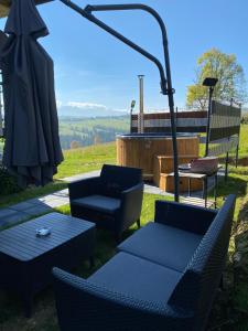 a patio with chairs and a table and an umbrella at Atlas Chmur Apartament in Biały Dunajec