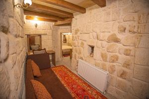 a room with a stone wall with a table and chairs at Pietra Cave Suites in Ürgüp +55 photos