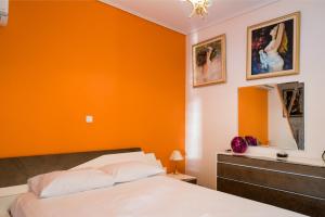 a bedroom with an orange wall and a bed at Flisvos Elite Seafront Luxury Apartment in Athens
