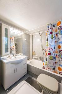 a bathroom with a sink and a tub and a shower curtain at Flisvos Elite Seafront Luxury Apartment in Athens +58 photos