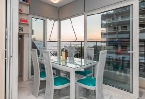 a dining room with a glass table and chairs at Flisvos Elite Seafront Luxury Apartment in Athens