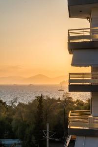 Flisvos Elite Seafront Luxury Apartment في أثينا: اطلالة على المحيط وقت الغروب من المبنى