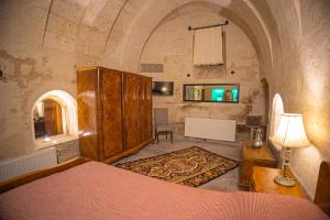 a bedroom with a bed and a table with a lamp at Pietra Cave Suites in Ürgüp