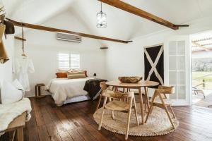 諾拉的住宿－Picturesque Barn located on the Shoalhaven River，卧室配有一张床和一张桌子及椅子