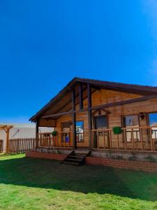 a large wooden house on a grassy field at أكواخ ريف الطائف in As Sayl aş Şaghīr