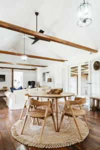 ein Wohnzimmer mit einem Tisch, Stühlen und einem Bett in der Unterkunft Picturesque Barn located on the Shoalhaven River in Nowra