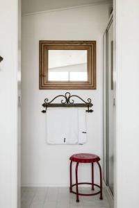 a red stool in a bathroom with a mirror at Picturesque Barn located on the Shoalhaven River in Nowra
