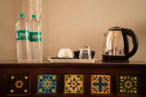 a table with a tea kettle and bottles of water at Helsinki Desert Camp in Jaisalmer