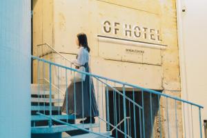 a woman walking down the stairs of a hotel at Of Hotel in Sendai