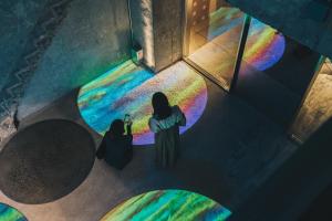 two women standing in a room with a rainbow at Of Hotel in Sendai