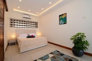 - une chambre avec un lit et une plante en pot dans l'établissement Residence Soleane, à Palmyre